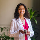 Dr. Evanthia Samota in a white lab coat holding Piotis Naturals Arkhé Calming Cream, a natural eczema treatment for dry and sensitive skin. Scientifically formulated in the UK using organic, eco-friendly ingredients to soothe and hydrate irritated skin.